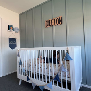Abella Cot side view showing mid-century inspired rounded spindle design